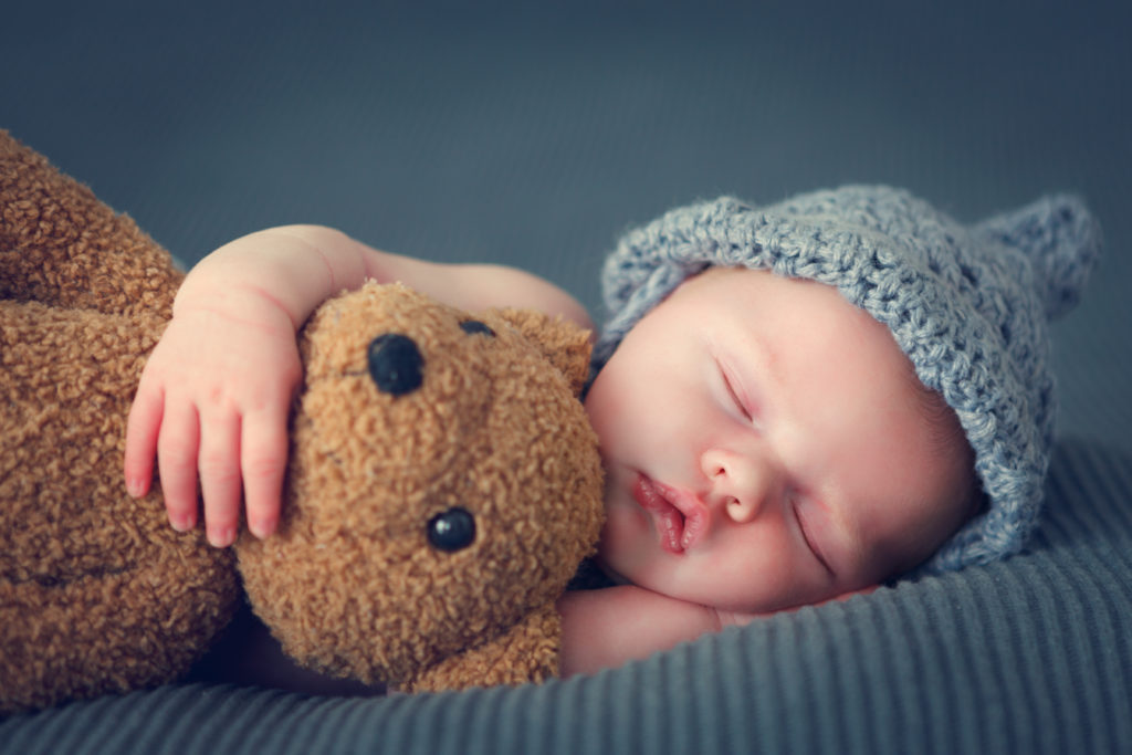 Un bébé qui dort avec son ours